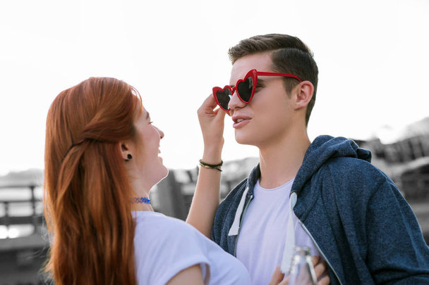 Young girl laughing while putting funny glasses on her boyfriend - Foto, afbeelding