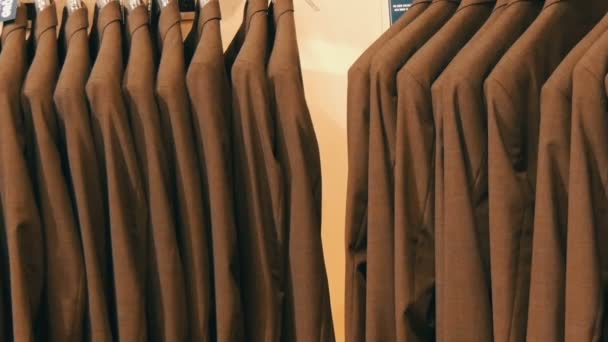 Numero di abiti da uomo dello stesso colore appesi a un appendiabiti in un negozio di abbigliamento in un centro commerciale
 - Filmati, video