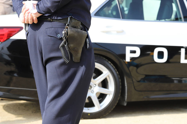 Vista posteriore dell'ufficiale di polizia giapponese con auto di pattuglia
  - Foto, immagini