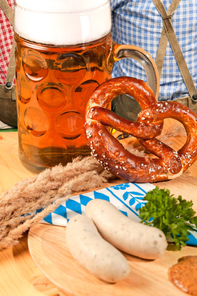 Mug of beer, pretzel and sausages on wooden table. Octoberfest concept - Foto, Imagem
