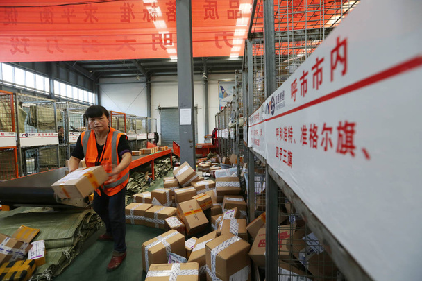 Chinese workers sort piles of parcels, most of which are from Singles Day online shopping, at a distribution center of an online snack vendor in Wuhan city, central China's Hubei province, 15 November 2016 - Foto, immagini
