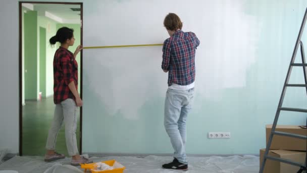 Diy couple measuring wall with measuring tape - Footage, Video