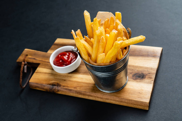 french fries on the black background - Foto, afbeelding