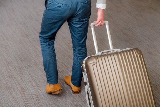 Close up of young business man with suitcase luggage on the carpet at the airport hall - Foto, Imagem