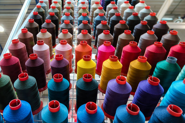 Bobine de fil de broderie colorée utilisant dans l'industrie du vêtement, rangée de rouleaux de fil multicolores, matériel de couture vendant sur le marché - Photo, image