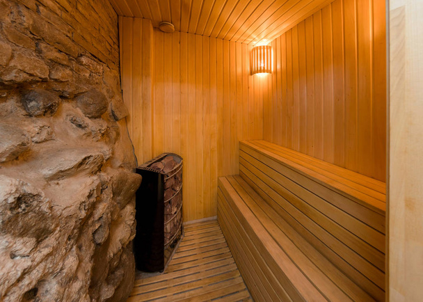 A l'intérieur d'un sauna moderne, paroi rocheuse et bancs en bois sur lesquels s'asseoir
 - Photo, image