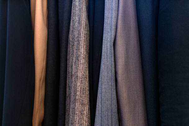 Υφές διαφορετικά ρούχα στην ντουλάπα, κοστούμια των επιχειρήσεων  - Φωτογραφία, εικόνα