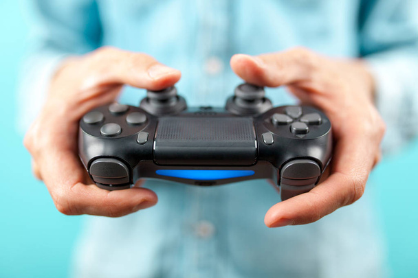 Mãos masculinas segurando um controlador de jogos
 - Foto, Imagem