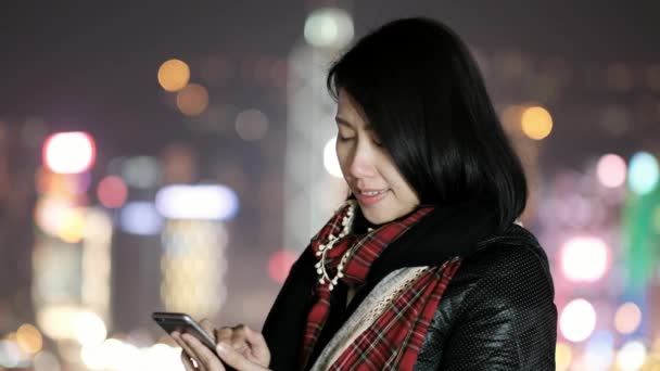 Frau benutzt Smartphone in der Nacht in Hongkong - Filmmaterial, Video
