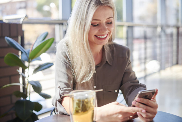 Красива жінка використовує телефон в кафе
 - Фото, зображення