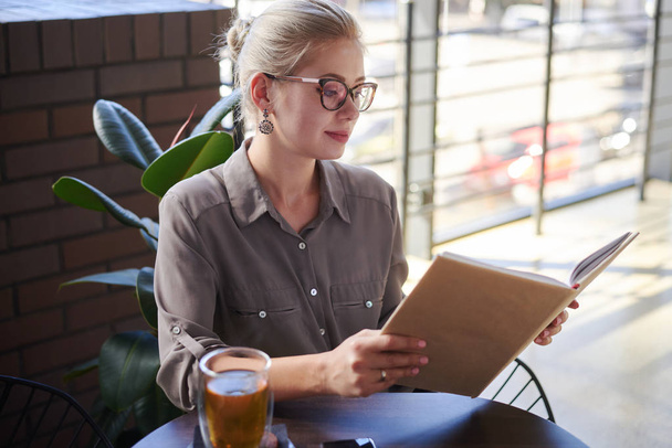 Piękna kobieta czytania książki w kawiarni - Zdjęcie, obraz