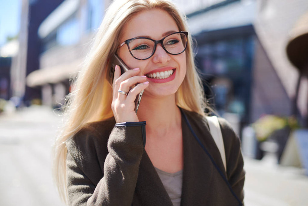 Happy woman talking on mobile phone in city - Foto, Bild