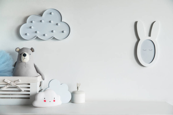 Stylish and cozy childroom with teddy bear, clouds and little mirror Bright and sunny interior. - Foto, afbeelding