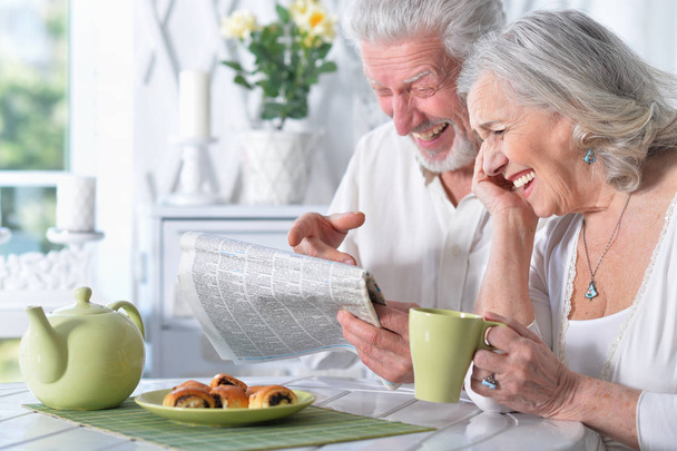 Close-up portrait of a  senior couple with newspaper  at home  - Foto, Imagem