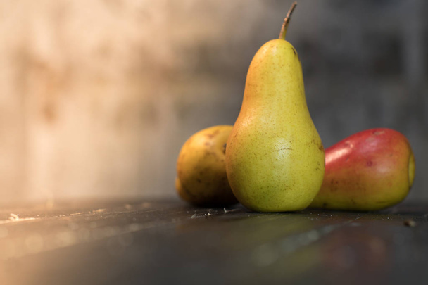 Group of ripe pears on dark rustic wooden table. Side view horizontal shot. Empty copyspace for your design. - Fotoğraf, Görsel