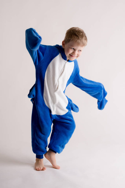 menino alegre posando em um fundo branco em pijama, traje de tubarão azul
 - Foto, Imagem