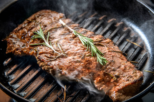 Beef steak with rosemary fried on a grill pan. - Photo, Image