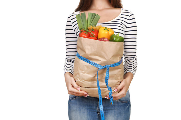 Woman holding grocery shopping bag on white background - Photo, Image