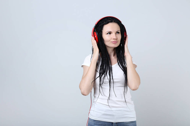 Cute young woman with headphones on grey background - Fotoğraf, Görsel