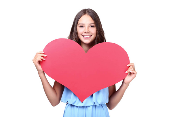 Молода дівчина тримає червоне паперове серце на білому тлі
 - Фото, зображення