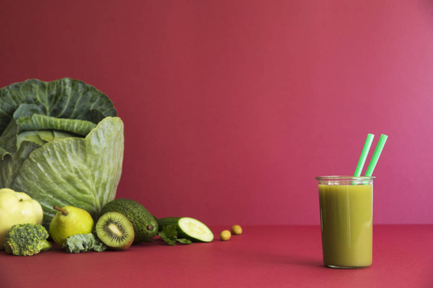 Fresh homemade smoothie with cabbage, avocado, kiwi and peach on pink background - Photo, Image