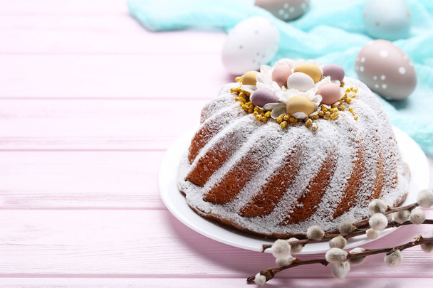 Easter cake with eggs and tree branches on pink wooden table - Fotografie, Obrázek