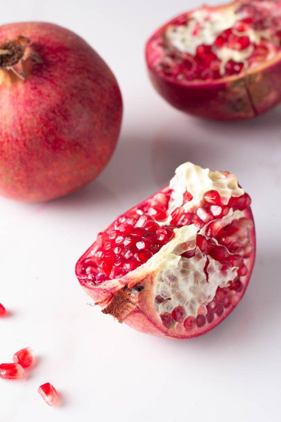 red pomegranate and pomegranate seeds on a white background - Photo, Image