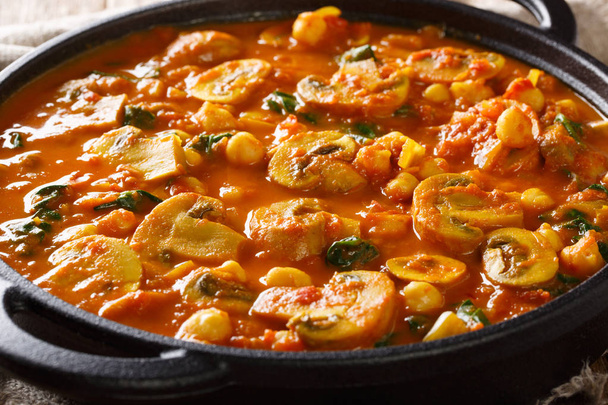 scharfes asiatisches Champignon-Curry mit Spinat und Kichererbsen aus nächster Nähe in einer Pfanne. Horizonte - Foto, Bild