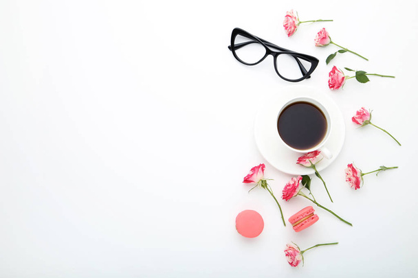 Rose flowers with cup of coffee and macarons on white background - Photo, image