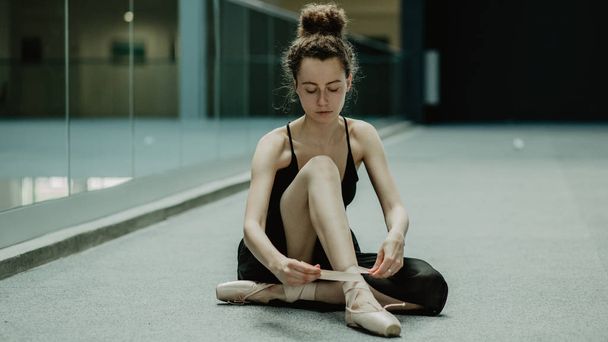 Ballerina putting on pointe shoes and preparing to training  - Foto, immagini