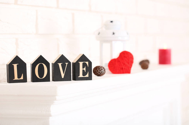 Word Love with cone and red heart on white fireplace - Fotoğraf, Görsel