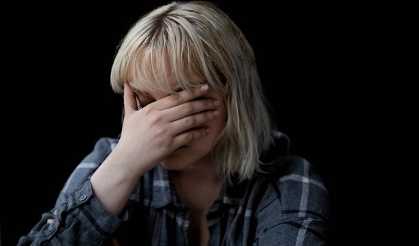 Portrait of sad depressed young woman on black background  - Фото, изображение