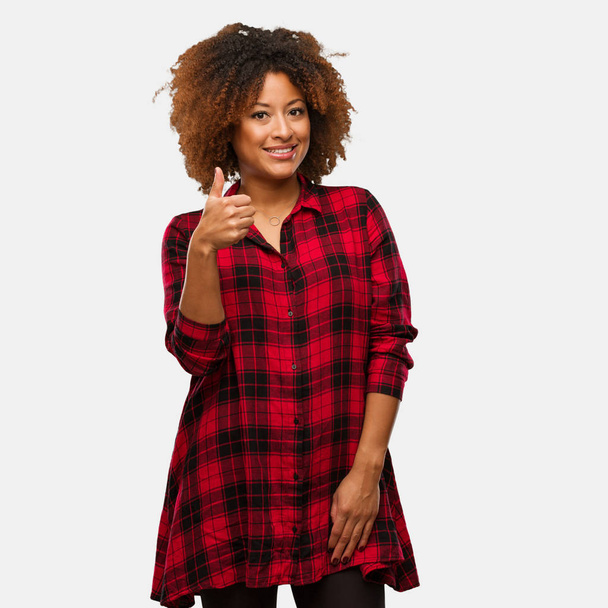 Jovem negra afro mulher sorrindo e levantando o polegar
 - Foto, Imagem
