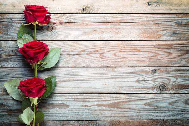 Bukiet czerwonych róż na tle rustykalne drewniane. - Zdjęcie, obraz
