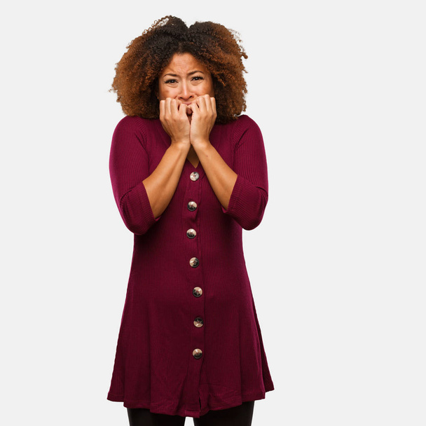 Nuori musta afro nainen puree kynnet, hermostunut ja hyvin ahdistunut
 - Valokuva, kuva