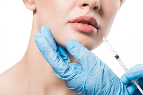 cropped shot of young woman receiving beauty injection in lips isolated on white - Foto, Bild