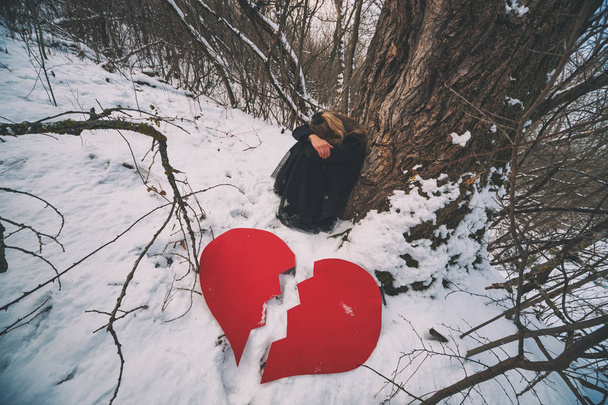 Deprese a zlomeným srdcem žena, opírající se o strom v lese v zimě. - Fotografie, Obrázek