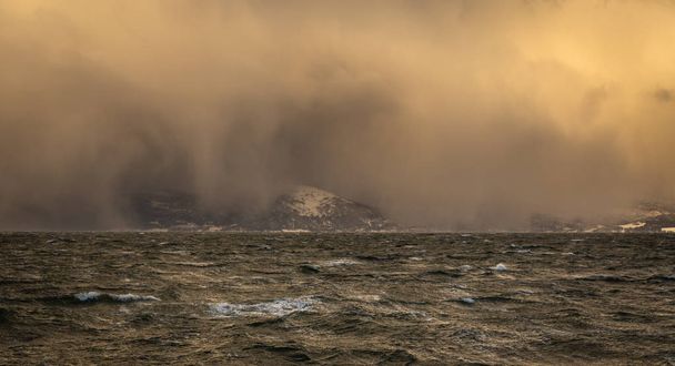 Winter stormy weather and incoming blizzard over Trondheimsfjorden near Trondheim, Norway. - Foto, afbeelding