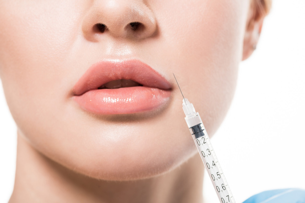 tiro cortado de mulher jovem recebendo injeção de beleza em lábios isolados em branco
  - Foto, Imagem