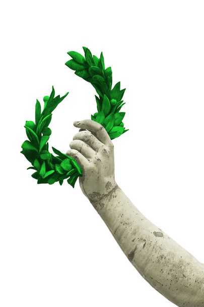 Hand houdt een groene laurier krans - bronzen standbeeld op een witte achtergrond voor gemakkelijke selectie - succes en roem concept beeld - Foto, afbeelding