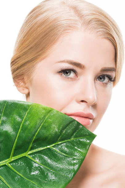 beautiful tender young woman with green tropical leaf looking at camera isolated on white - Photo, Image