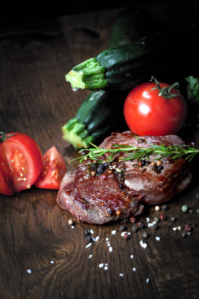 Close up view of delicious steak with herbs and spices on wooden table - Foto, Imagen