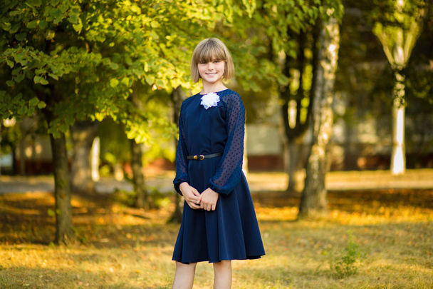 Venkovní portrét šťastná Malá školačka ve školní uniformě v parku. Zpátky do školy. - Fotografie, Obrázek