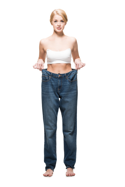 vista comprimento total da menina magro descalço vestindo jeans oversized e olhando para a câmera isolada no branco
 - Foto, Imagem