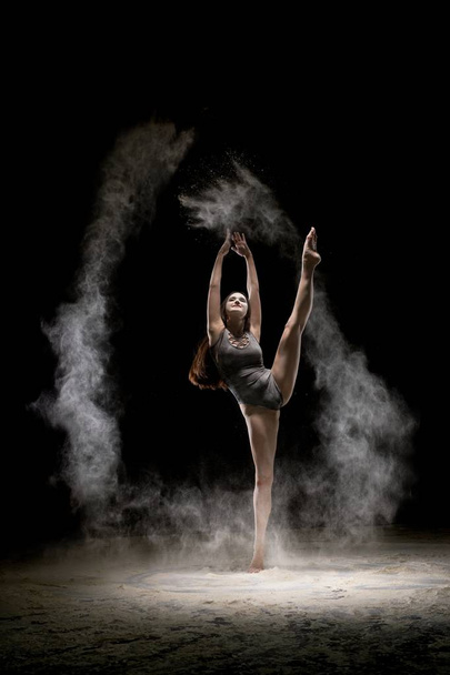 Gorgeous μελαχρινή χορεύουν σε σκόνη στο σκοτάδι - Φωτογραφία, εικόνα