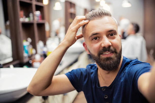 Hipster man client in barber shop, taking seflie. - Foto, Imagen