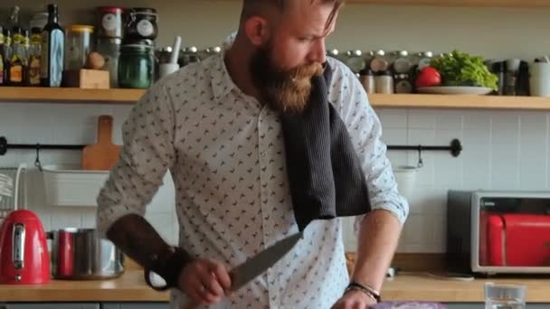 Charismatic male hipster is cooking in the kitchen. - Metraje, vídeo
