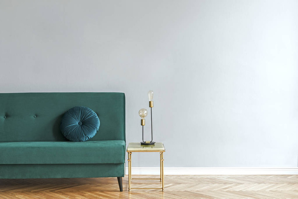 Minimalistic interior with green velvet couch on wooden floor - Фото, изображение