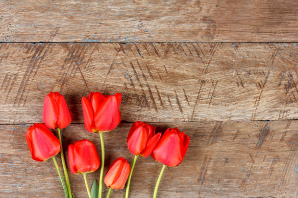 bukiet czerwonych tulipanów na drewniane retro streszczenie tło z miejsca kopii. Koncepcja dzień matki, dzień kobiet, widok z góry - Zdjęcie, obraz