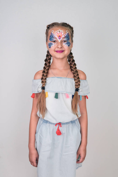Beautiful little girl with aqua make-up on a white background. face painting - Foto, Imagen